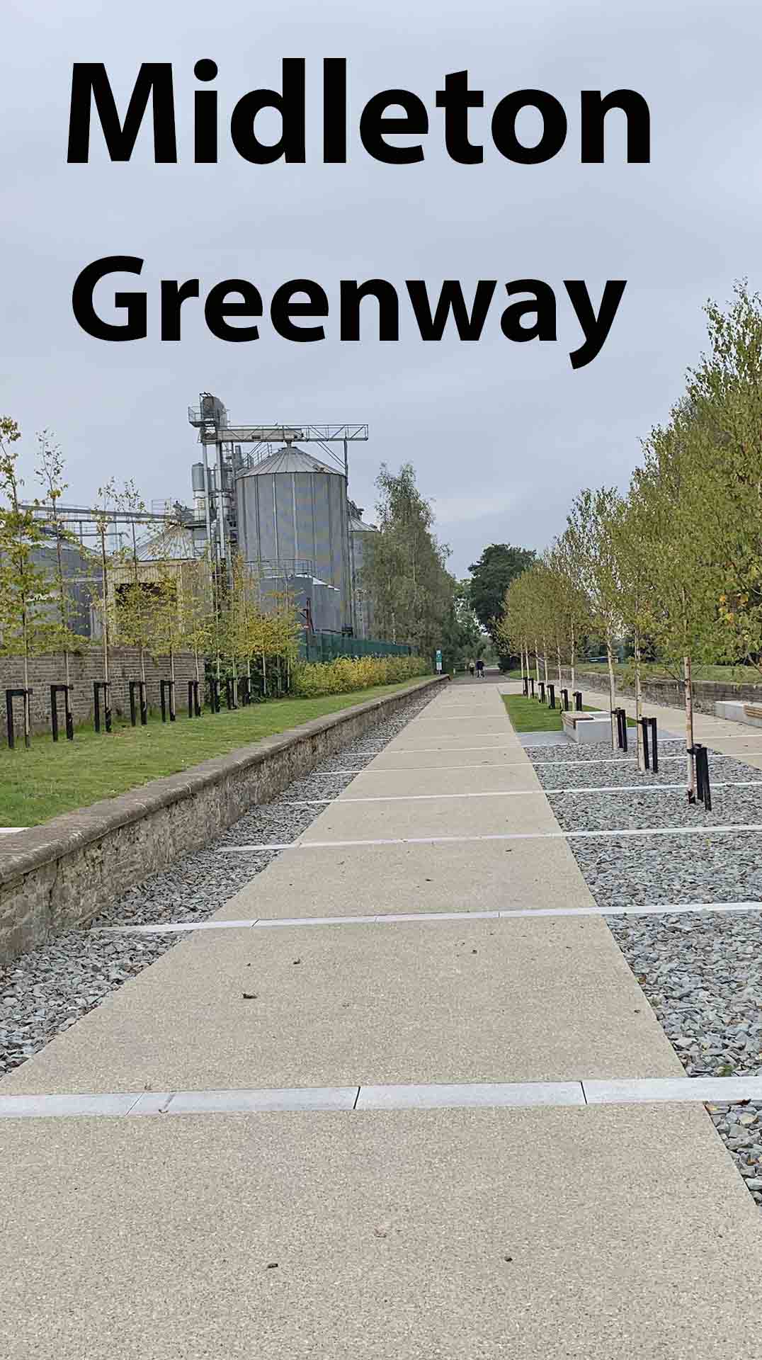 a sidewalk with trees and a silo