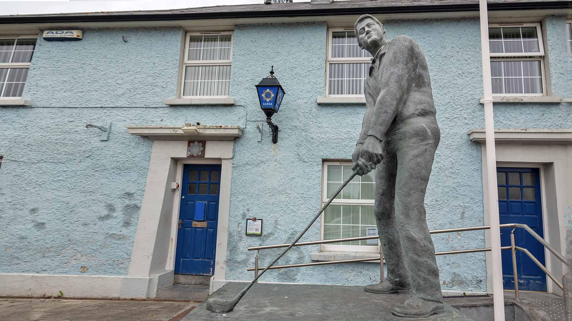 a statue of a man holding a golf club