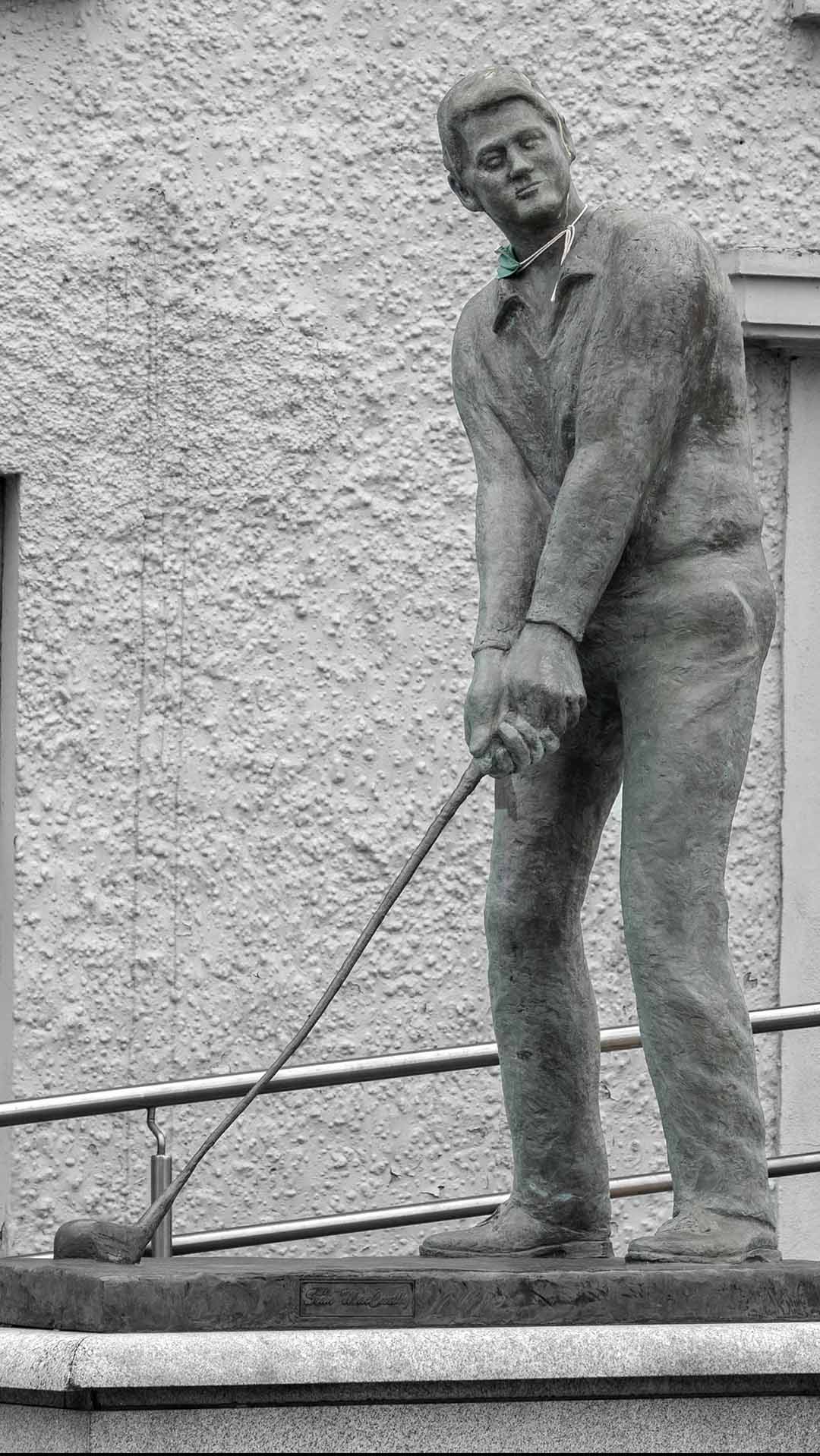 a statue Bill Clinton holding a golf club