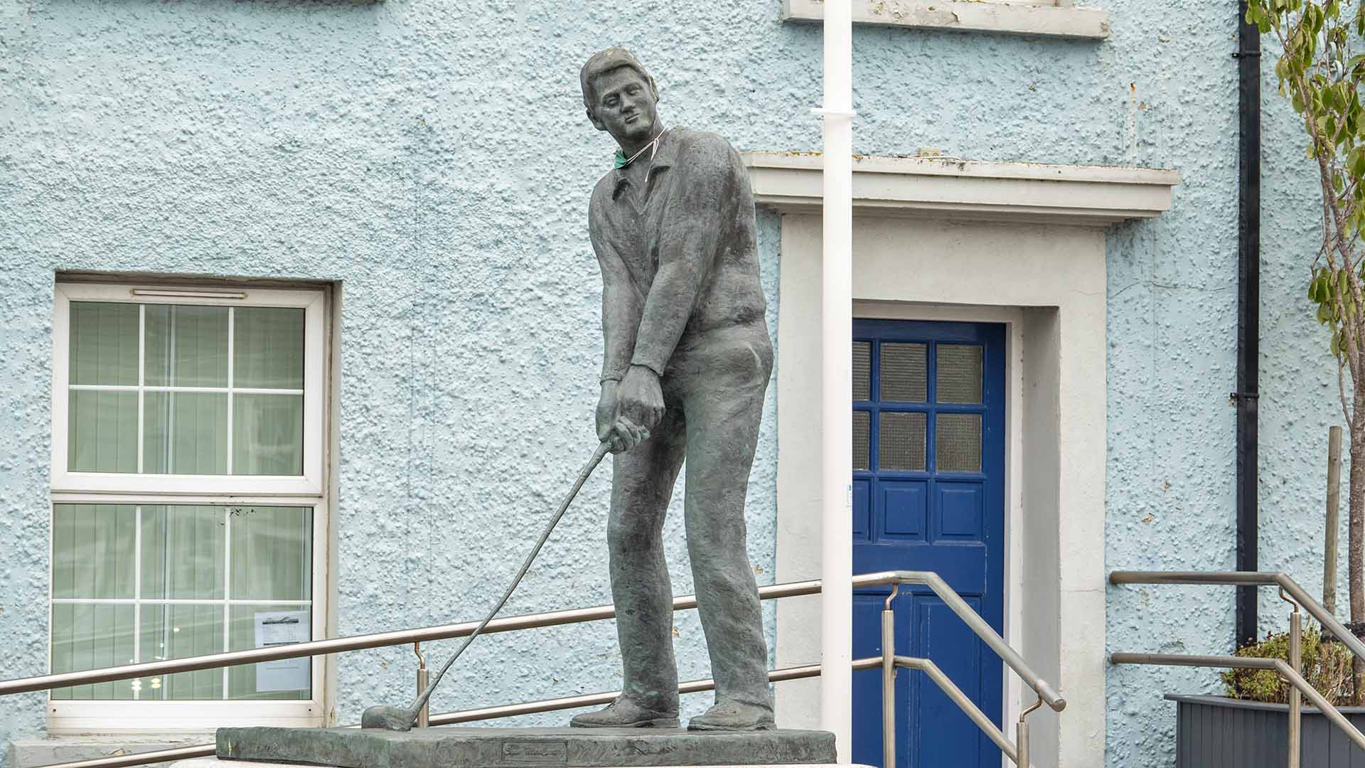 a statue of a man holding a golf club