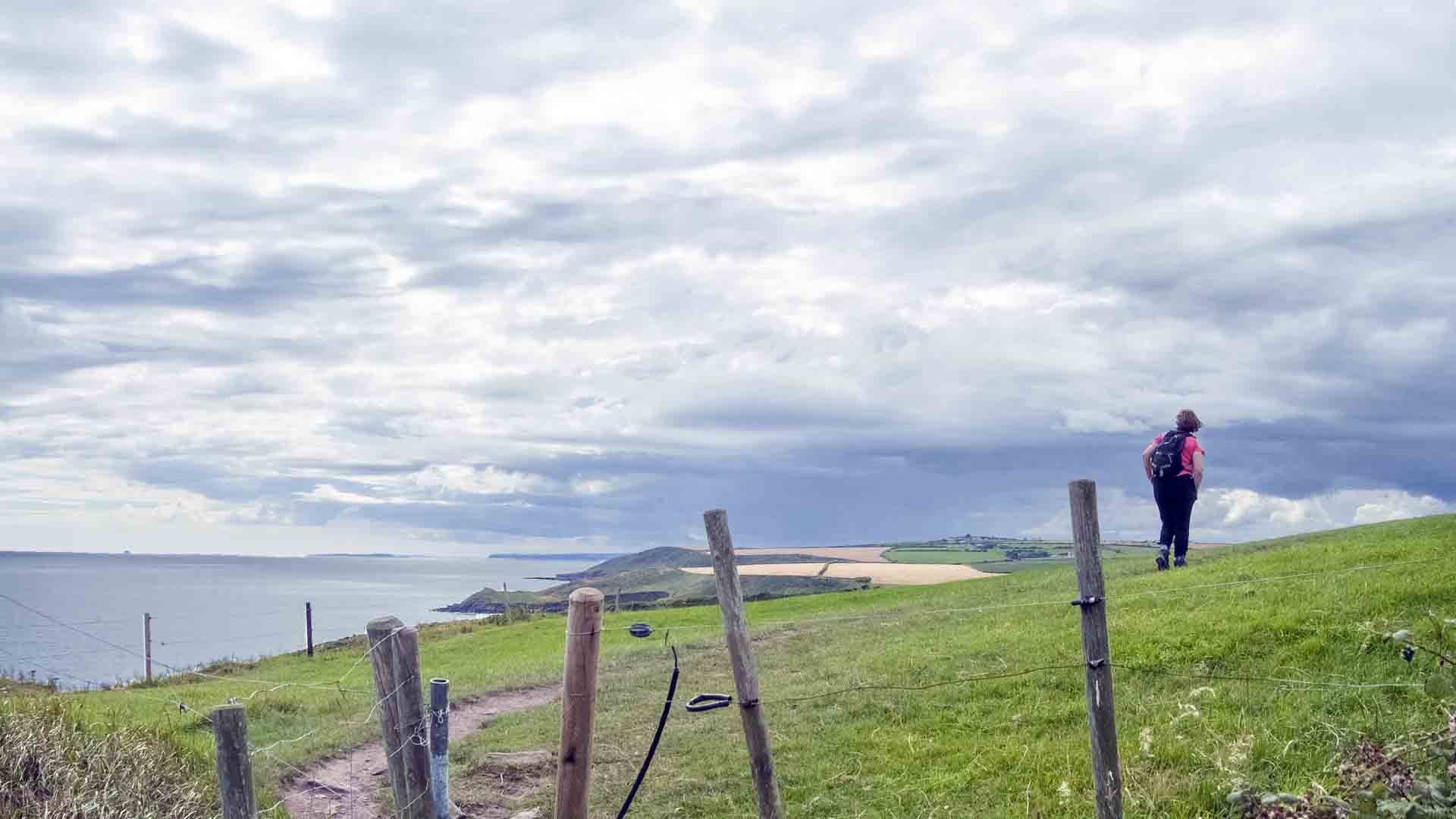 a fenced in field with a body of water in the background