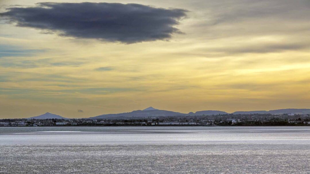 a body of water with a city in the distance