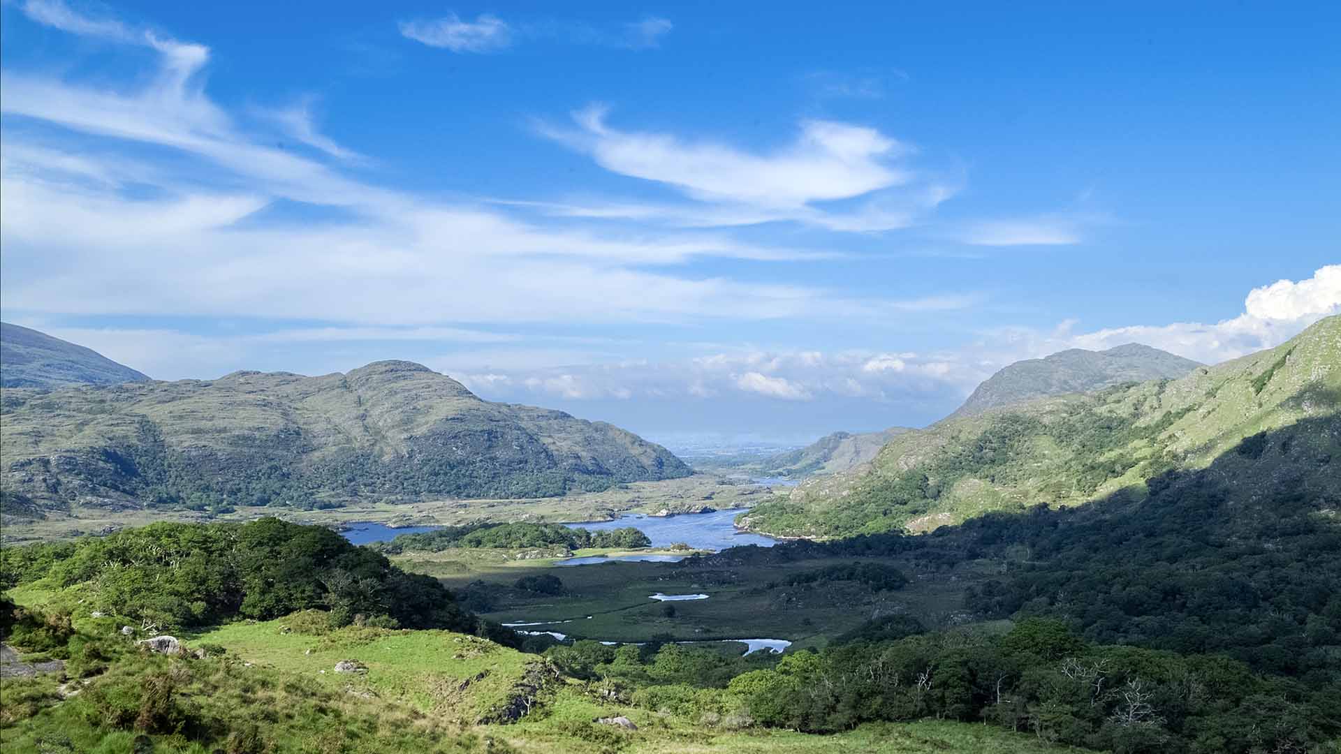 a landscape with a river and mountains