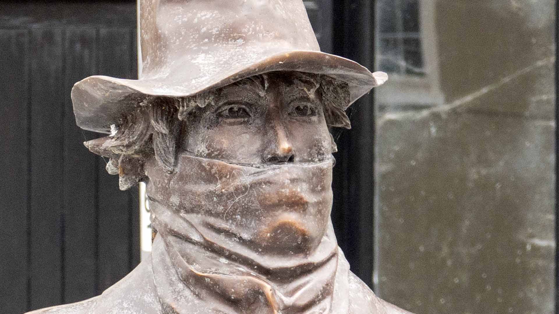 a statue of a man wearing a hat and scarf