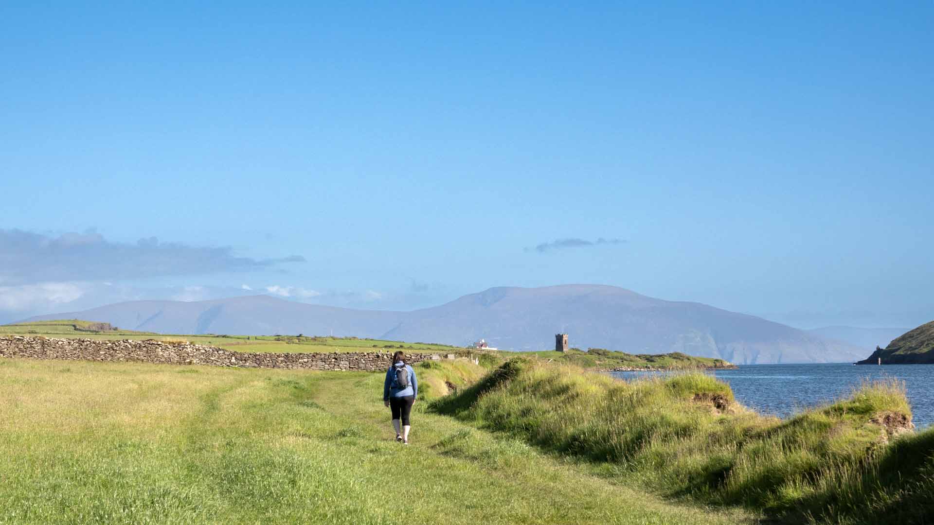 a person walking on a path by water