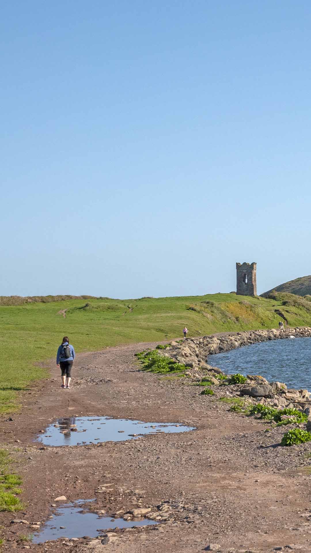 a person walking on a path near a body of water