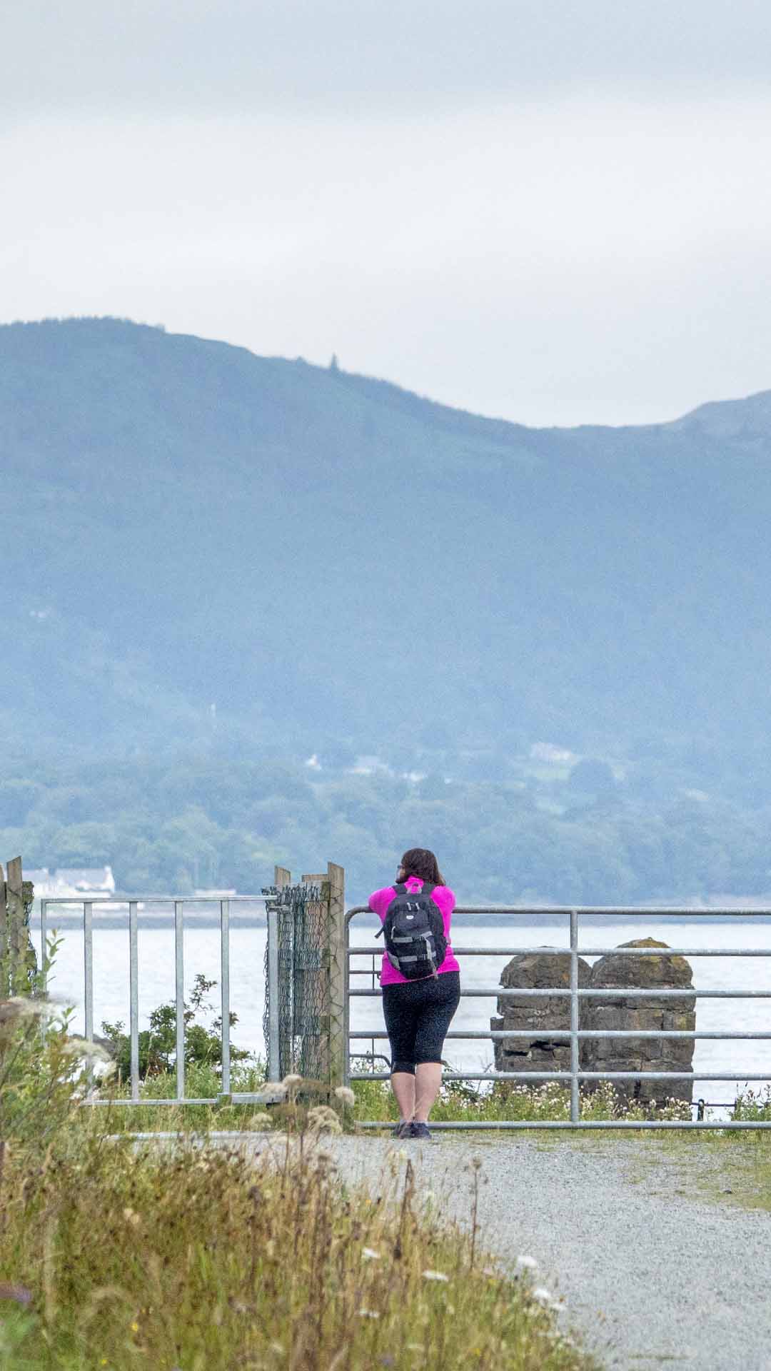 a woman standing on a railing overlooking a body of water