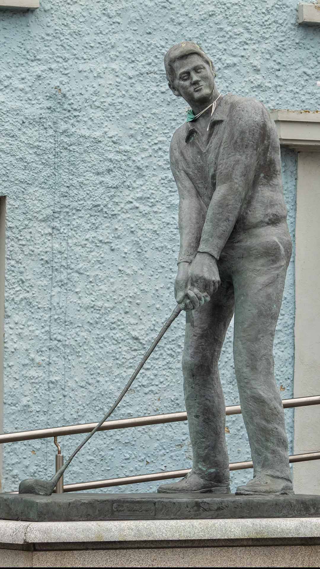 a statue Bill Clinton holding a golf club